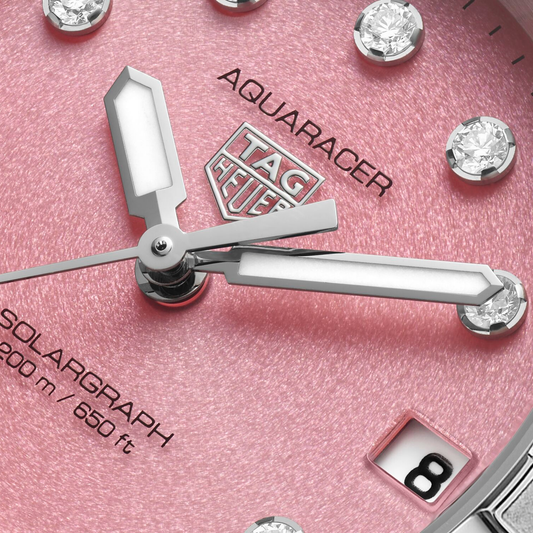 close-up of the pink dial highlighting the shimmering finish, diamond-set indexes, and clean, luminous hands for refined readability