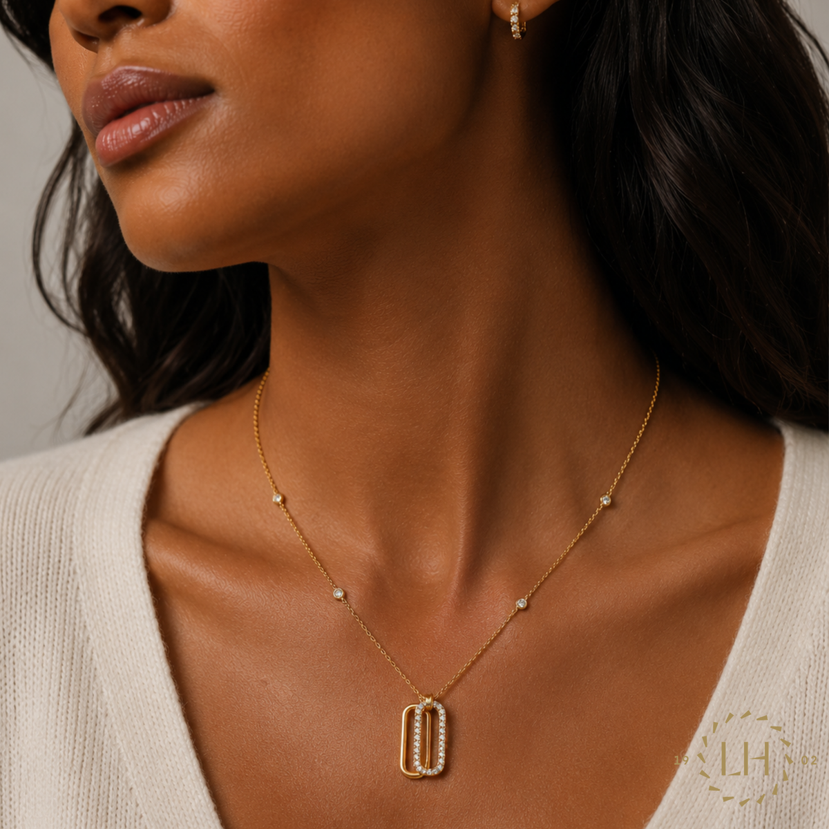 A contemporary open oval pendant crafted in 18ct rose gold and adorned with 0.50ct of sparkling diamonds, suspended from a delicate diamond station chain on a modal. 