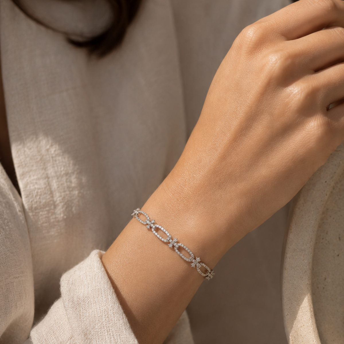 Model wearing an 18ct white gold diamond link bracelet featuring elegant diamond-set oval links