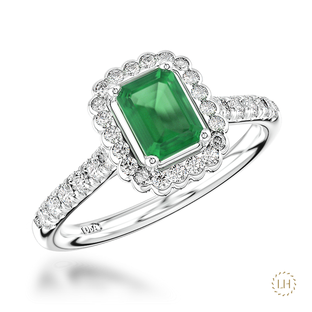 Classic cluster styling is given a beautifully refined finish in this Platinum Emerald and Diamond Ring. At the centre sits a captivating 0.68ct emerald, bringing a rich flash of green colour to this elegant and timeless design.