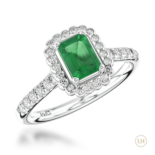 Classic cluster styling is given a beautifully refined finish in this Platinum Emerald and Diamond Ring. At the centre sits a captivating 0.68ct emerald, bringing a rich flash of green colour to this elegant and timeless design.