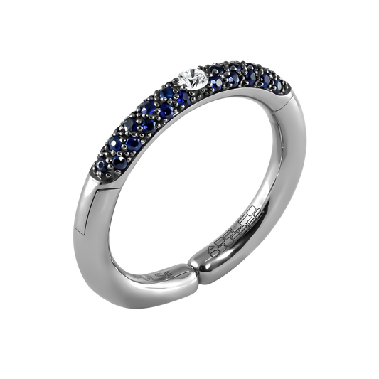 A striking blend of colour and brilliance, this 18ct white gold Populse Jeans ring features a 0.09ct brilliant round diamond, framed by a flowing half eternity of vivid blue sapphires for a bold yet elegant finish.