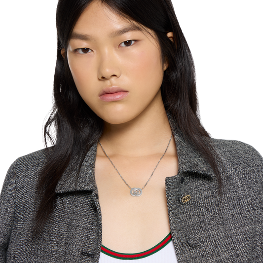 Crafted in Italy from premium sterling silver, this authentic Gucci necklace showcases the signature Interlocking G pendant suspended from a sleek chain. A timeless designer piece that blends understated elegance with iconic branding.