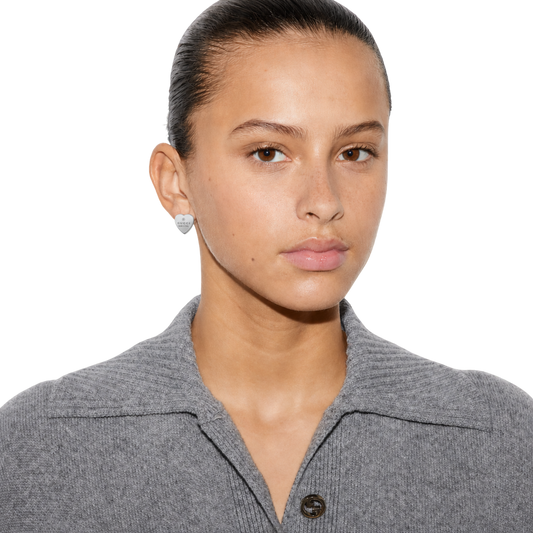 Model wearing the Gucci Trademark stud heart earrings in 925 sterling silver.