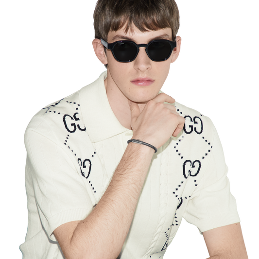 This Gucci Trademark bracelet showcases the house’s iconic GG Supreme canvas in a sophisticated black and dark grey colourway, paired with polished 925 sterling silver detailing. Finished with an engraved logo tag, it delivers understated luxury with a modern edge that works seamlessly across casual and elevated styling.