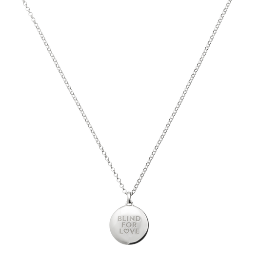 Round silver pendant necklace engraved with “Blind For Love”, featuring a clean minimalist design and fine chain for effortless everyday styling.