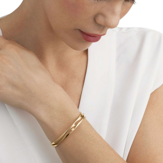 Designed by Nina Koppel, this Fusion Open Bangle showcases sculptural curves in polished 18ct yellow gold, creating a timeless piece that's both contemporary and elegant. Available in medium.