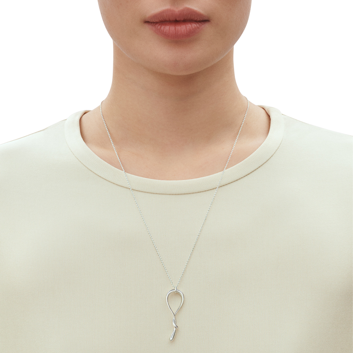 With its elegant swirl silhouette and polished finish, this necklace catches the light beautifully as it moves. The elongated shape creates a flattering look at the neckline, adding interest without being overly bold. It's the sort of piece that works just as well with a simple white shirt as it does with an evening outfit.