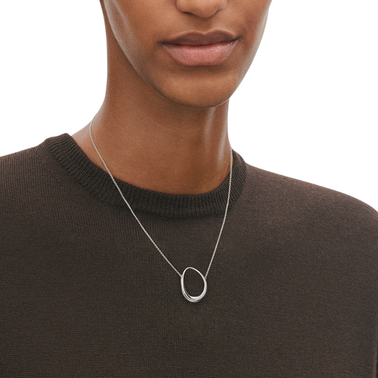 Front lifestyle view of a model wearing the Georg Jensen Offspring Medium Sterling Silver Pendant Necklace, featuring an organic open-circle pendant on a fine silver chain.