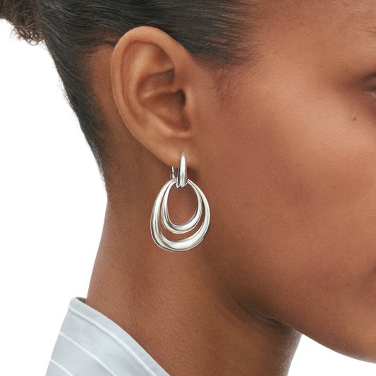 These earrings have a confident, contemporary feel that works effortlessly from day to evening. The polished silver finish catches the light as you move, while the larger design frames the face beautifully without feeling too heavy or overpowering.