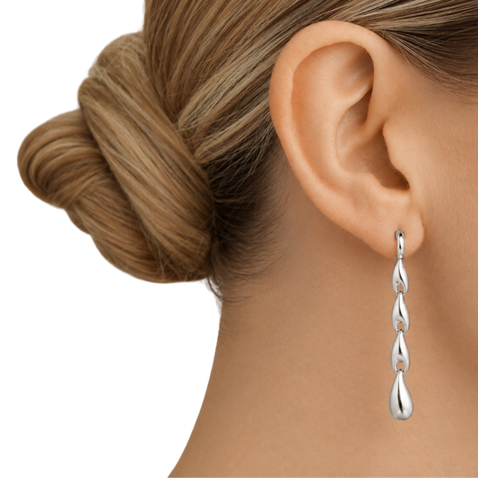 Designed with a sequence of organic silver links that flow into a teardrop-shaped drop, they bring movement, structure and a real sense of contemporary style without feeling heavy or overworked.