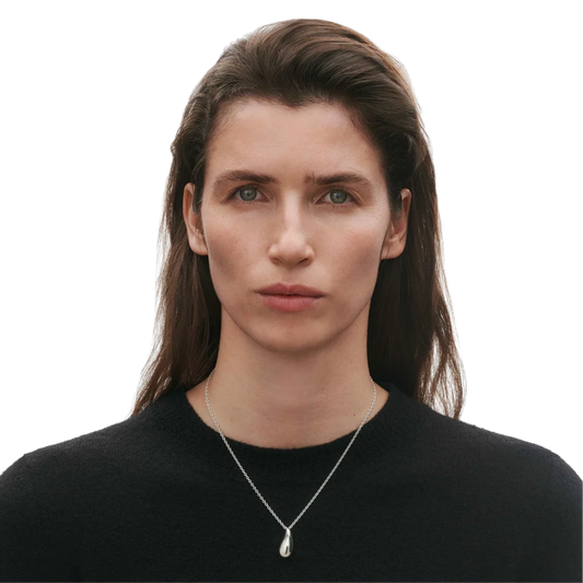 Crafted in sterling silver, its single sculptural link sits neatly at the neckline, creating a simple but striking silhouette that feels effortless to wear every day.