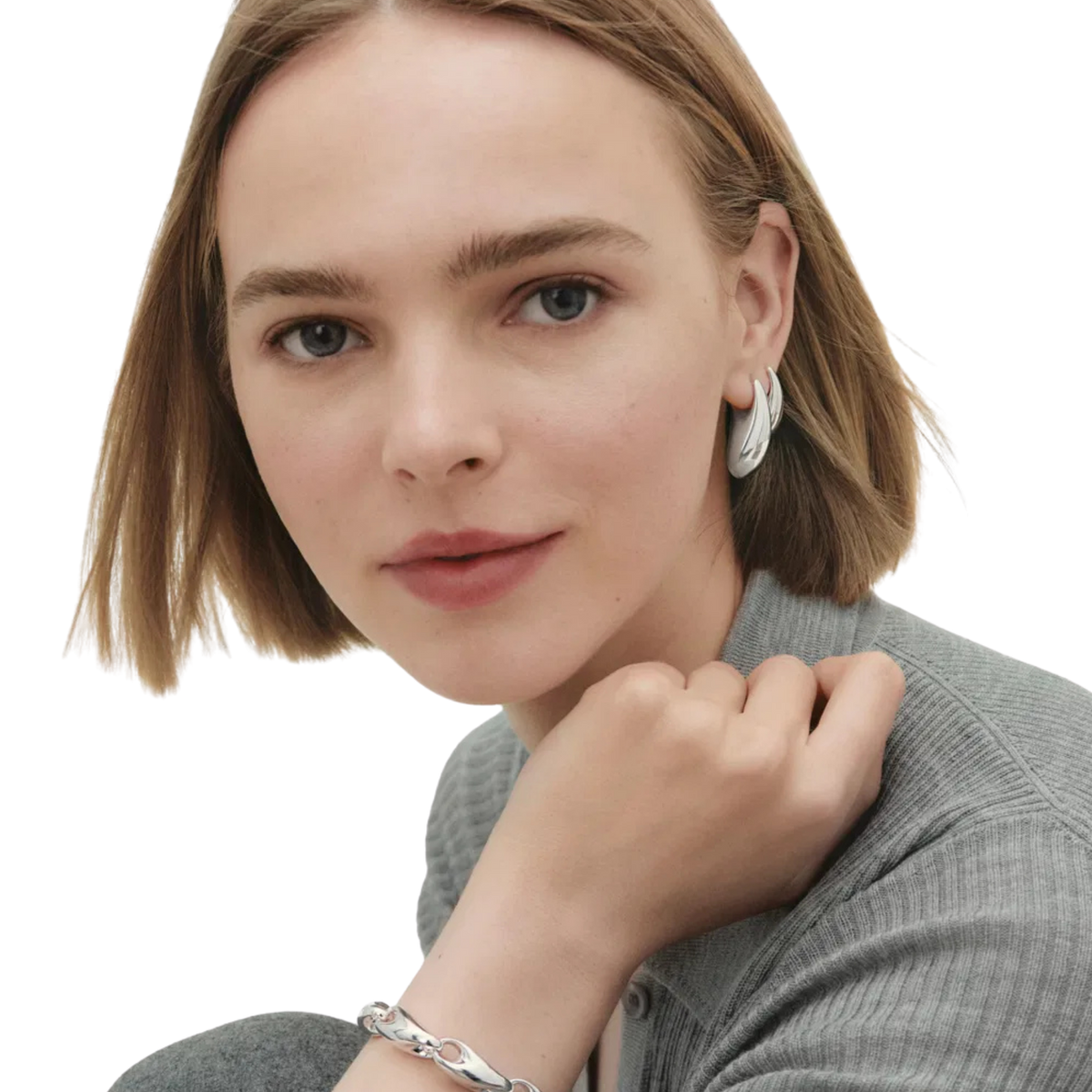 Crafted from sterling silver, each earring features the collection's signature sculptural form, creating a confident yet refined silhouette. 