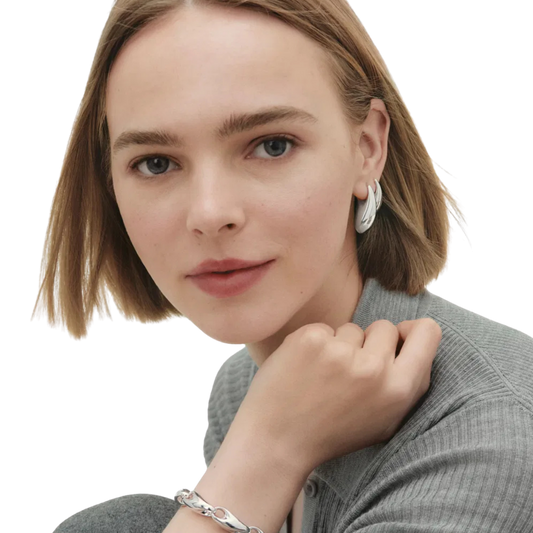 Crafted from sterling silver, each earring features the collection's signature sculptural form, creating a confident yet refined silhouette. 