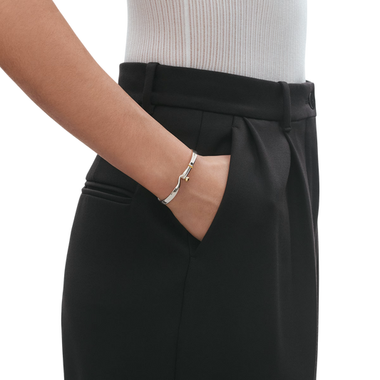Designed by Vivianna Torun Bülow-Hübe, this Torun Bangle blends sculptural Scandinavian style with polished sterling silver and 18ct yellow gold for effortless everyday elegance. Available in medium.