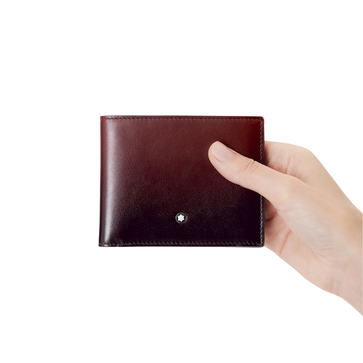 Hand holding the Montblanc Meisterstück Wallet 6CC in burgundy leather.