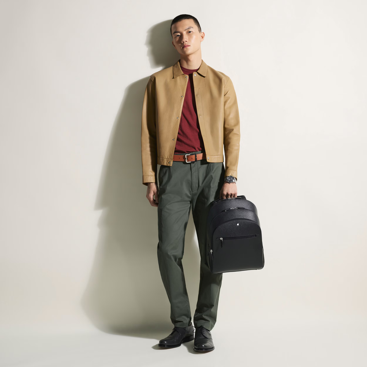 Model carrying the Montblanc Sartorial Medium Backpack in black leather.