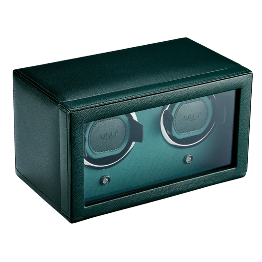 The WOLF 1834 Double Cub Watch Winder with Cover in Green is presented in a sleek, hexagonal silhouette finished in premium vegan leather. Its compact, modern design with protective cover highlights both security and elegance, making it a refined storage solution for two automatic watches. A statement piece for collectors who value precision and understated luxury.