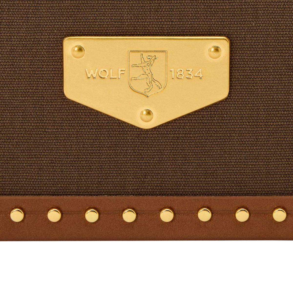 The exterior combines durable recycled canvas with rich leather detailing and brass stud accents.
A custom lock and reinforced corners add both security and structure.
Every element is designed to feel substantial, practical, and long-lasting.