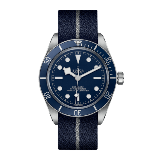 Tudor stainless steel dive watch with blue dial, luminous hour markers and blue unidirectional bezel on fabric strap