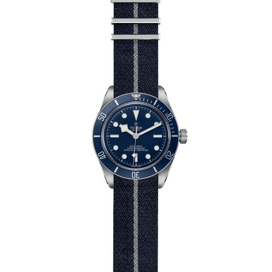 full view of Tudor watch showing the complete blue fabric strap and balanced case profile