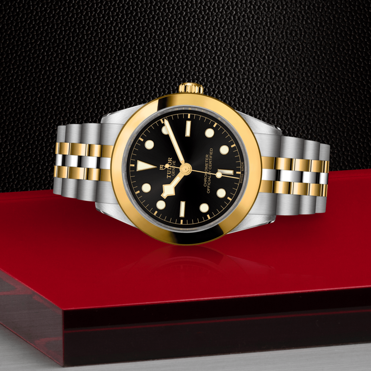 Tudor Black Bay One watch positioned on its side highlighting the polished case, yellow gold bezel and screw-down crown
