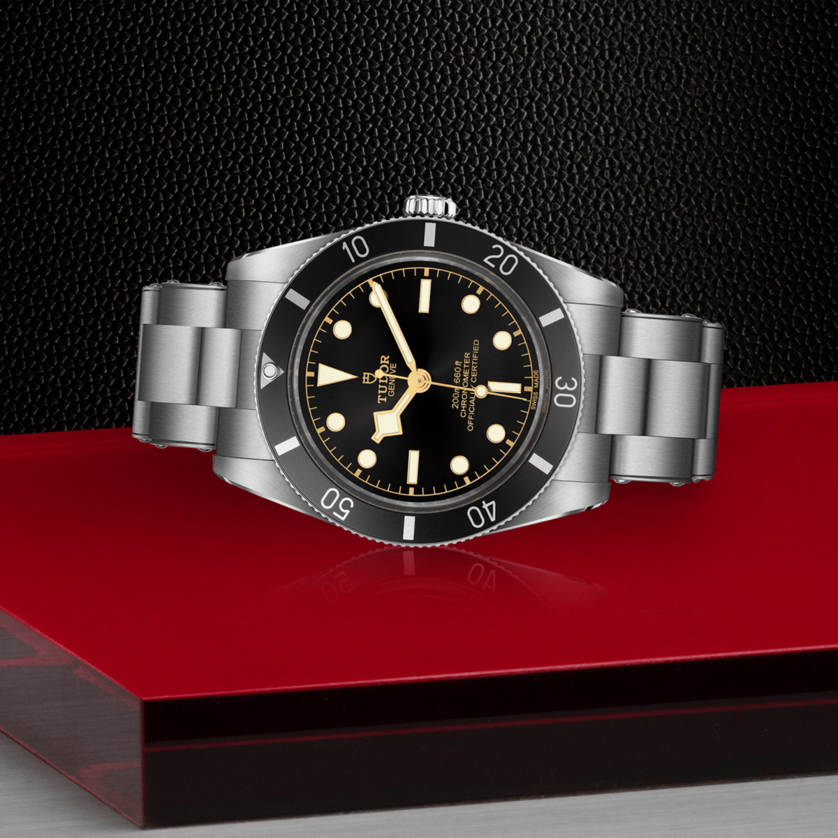 Tudor watch positioned on its side highlighting the case thickness, black bezel edge and screw-down crown detail