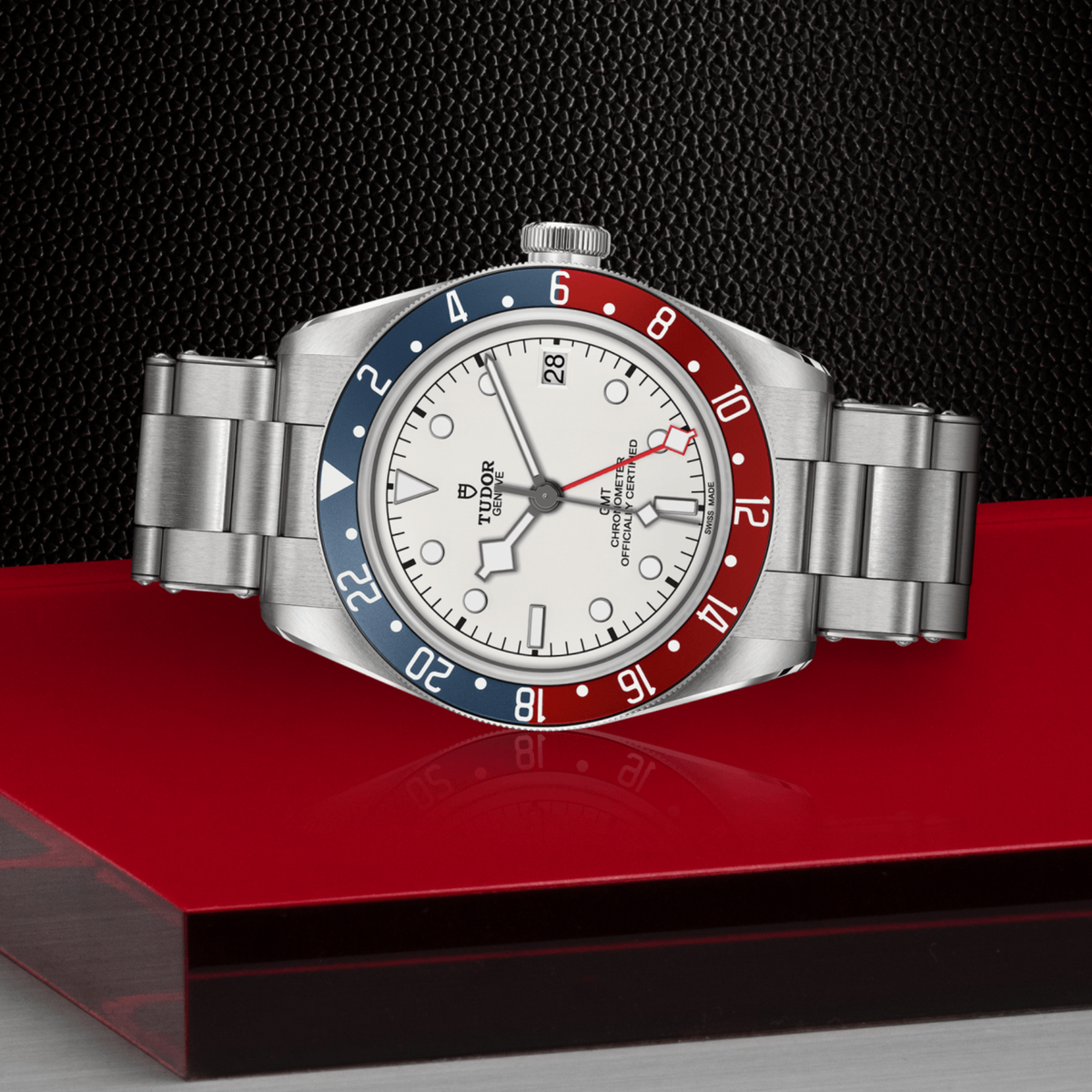 close-up of the opaline dial showing the red GMT hand, luminous markers and date window at 3 o’clock