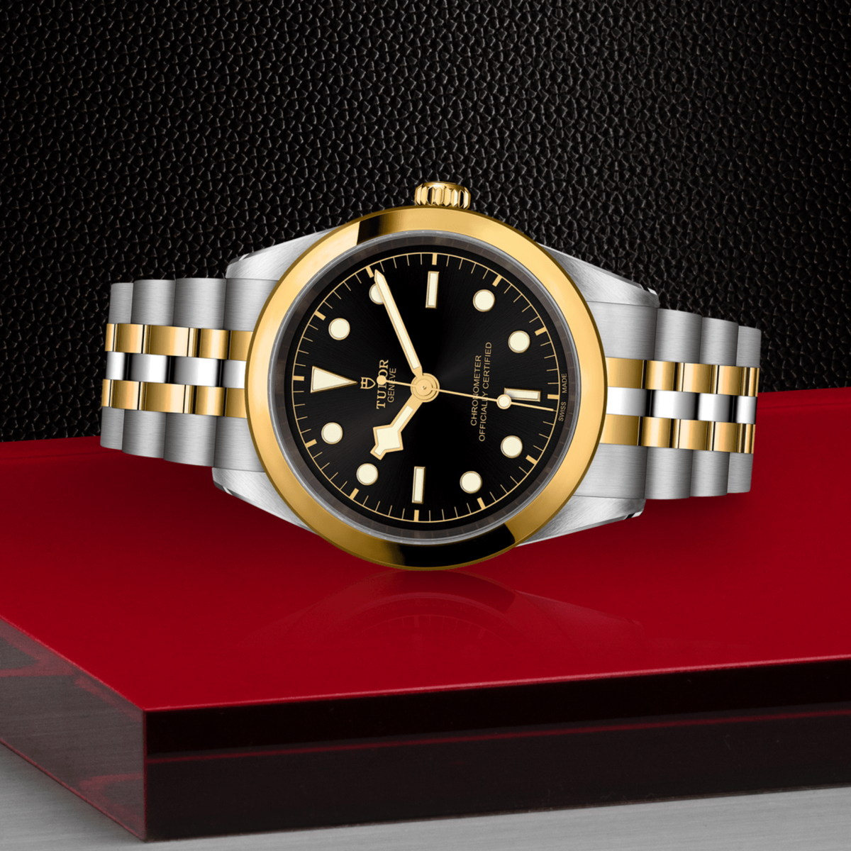 Tudor Black Bay One watch positioned on its side highlighting the polished case, yellow gold bezel and screw-down crown