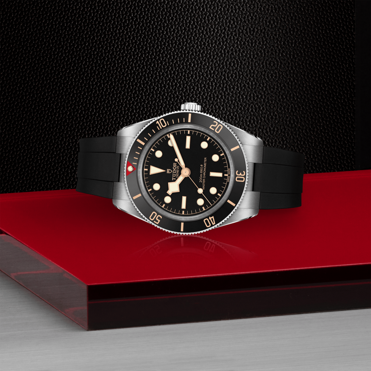 Black Bay 58 Watch with black strap and silver case on a red platform against a dark background