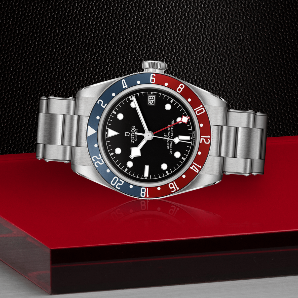 close-up of the black dial highlighting the GMT hand, luminous markers and date window