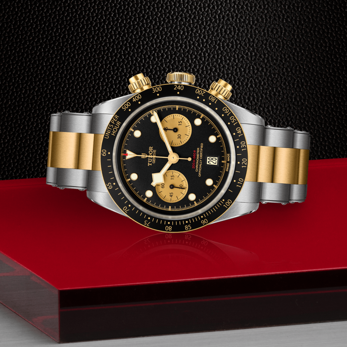 Tudor chronograph positioned on its side highlighting the case thickness, tachymeter bezel edge, crown and gold pushers