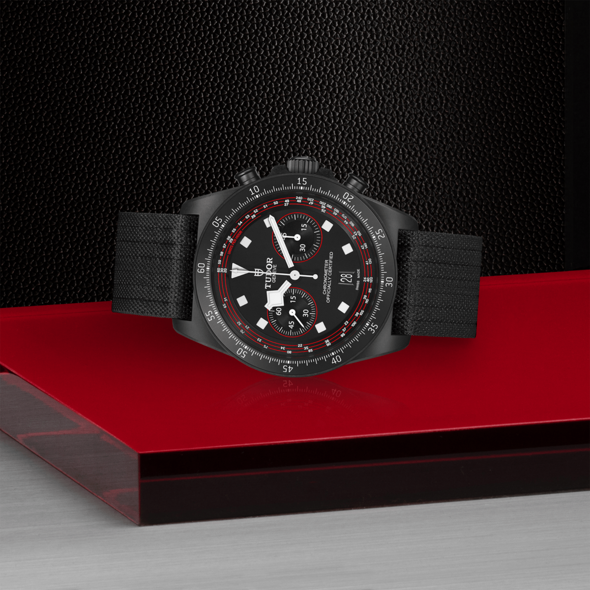 close-up of the black dial highlighting the chronograph sub-dials, red detailing and date window