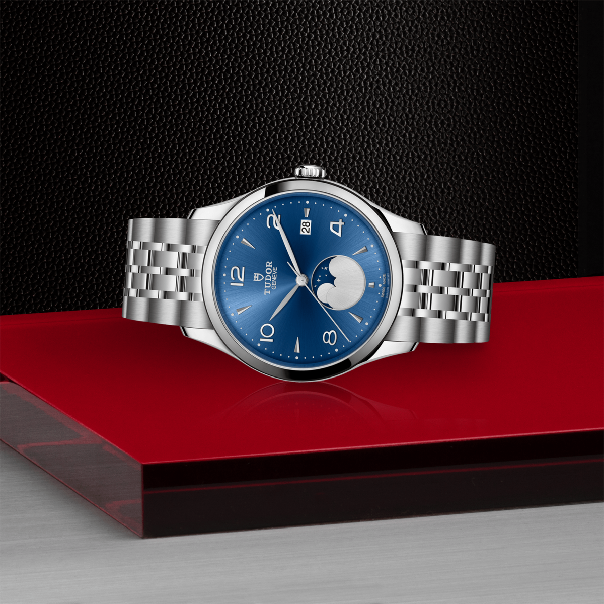 close-up of the blue dial showing the moonphase complication, Arabic numerals and date window