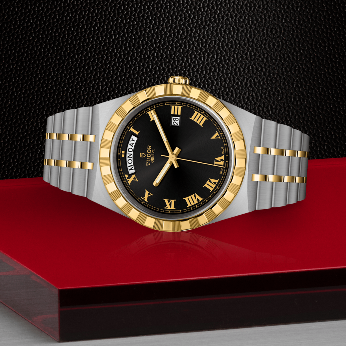 Tudor watch positioned on its side highlighting the case thickness, yellow gold notched bezel edge and screw-down crown detail
