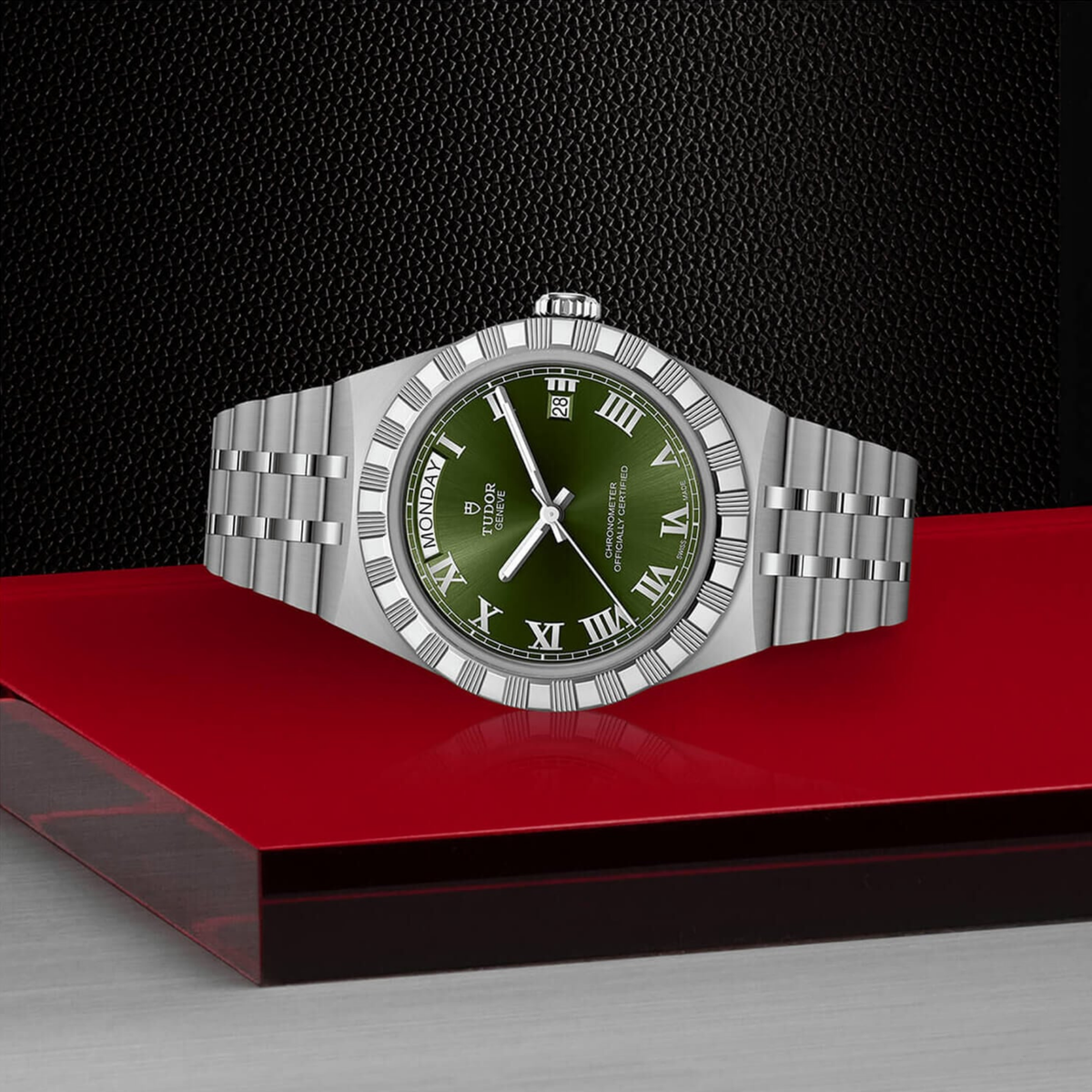 The rich green dial features applied Roman numeral hour markers, with a day display positioned at 12 o'clock and date window at 3 o'clock. Baton hands with Swiss Super-LumiNova® provide enhanced visibility, while scratch-resistant sapphire crystal protects the dial.