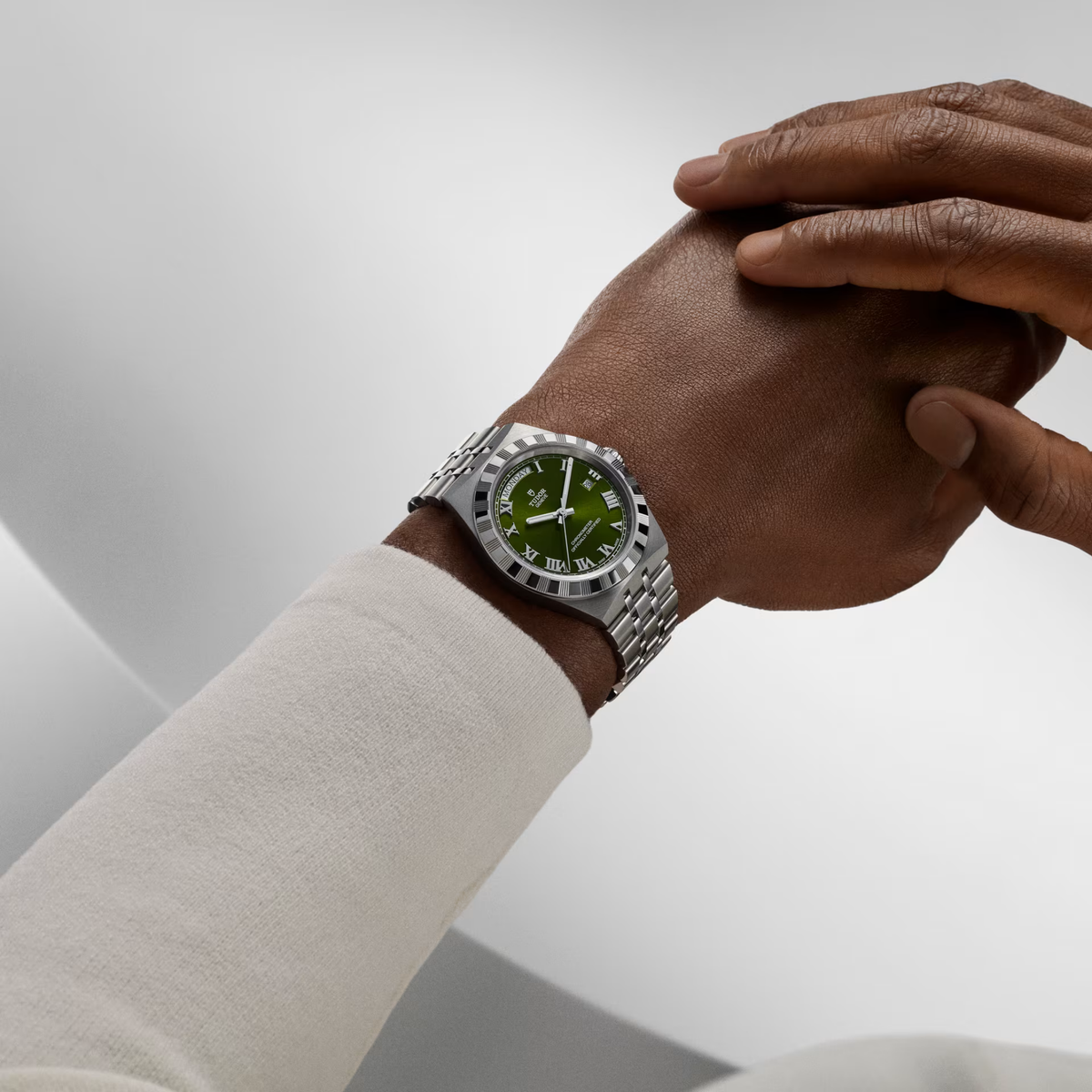 TUDOR Royal automatic watch featuring a 40mm stainless steel case, green Roman numeral day-date dial and integrated five-link steel bracelet with T-fit clasp on a model.