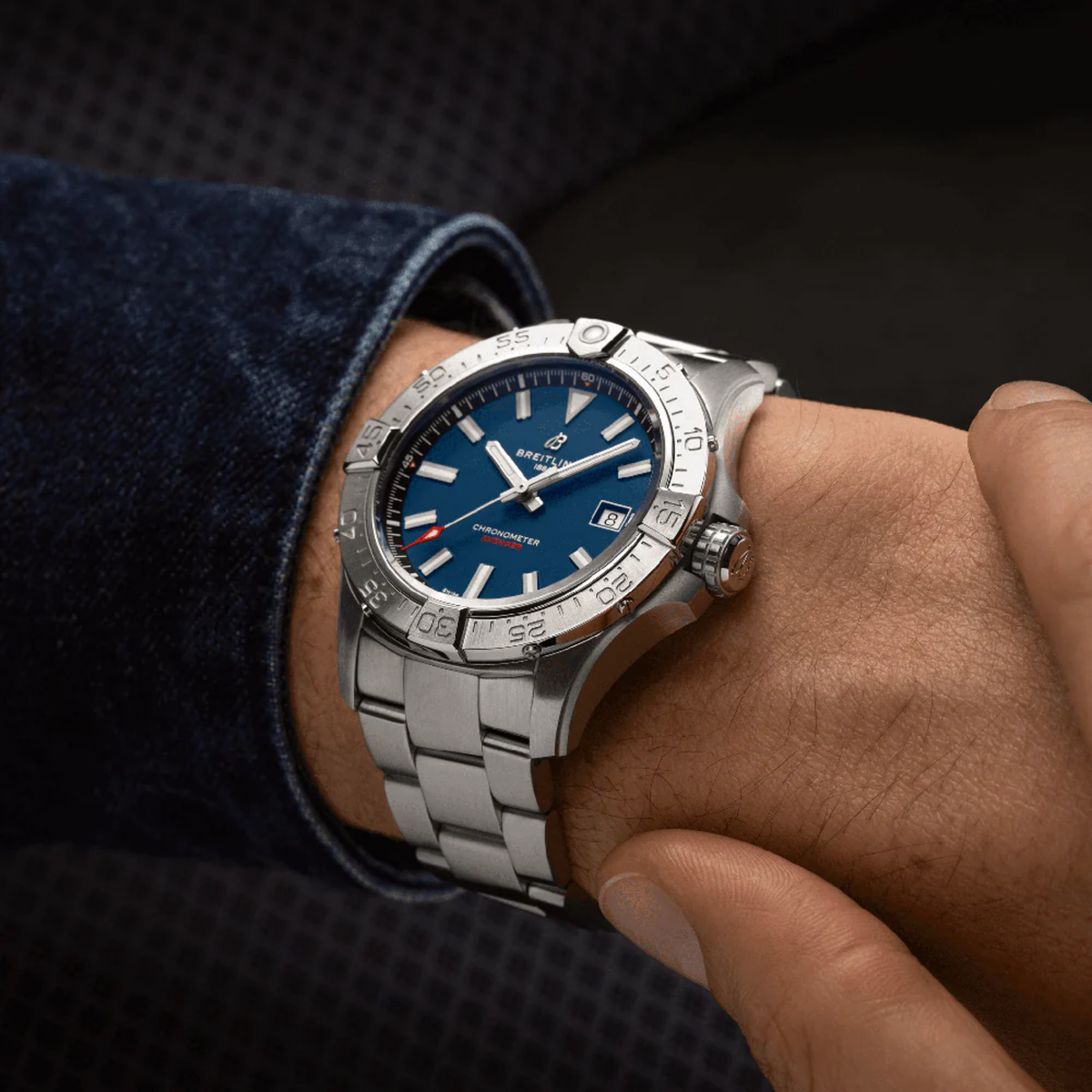 Luxury stainless steel watch with blue dial and chronometer certification on wrist