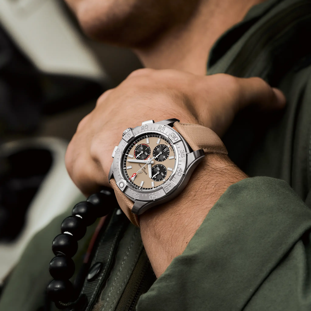 Stylish chronograph watch with beige dial and tan strap worn on wrist
