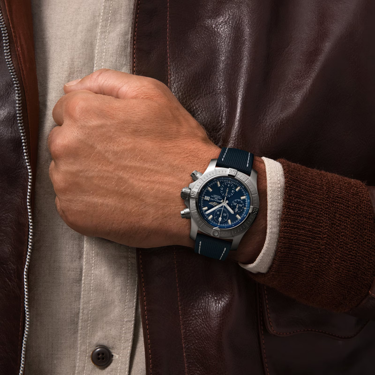 Luxury chronograph watch with blue dial and navy strap worn on wrist