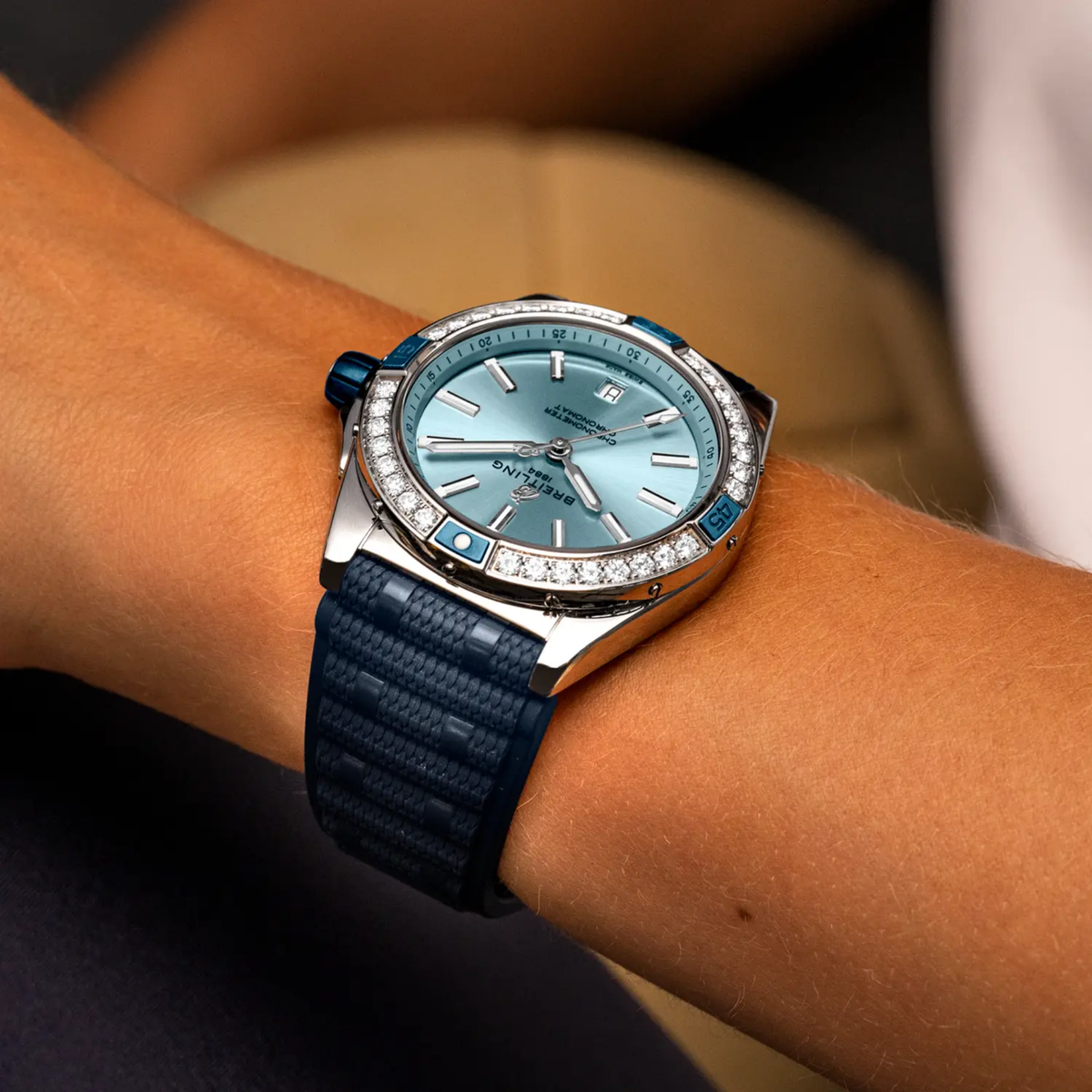 Breitling Chronomat Automatic blue dial diamond bezel watch worn on wrist with blue rubber strap