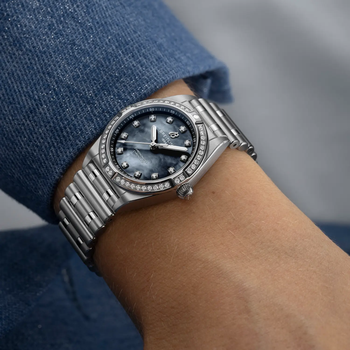 reitling Chronomat Automatic black mother of pearl dial diamond bezel watch worn on wrist with stainless steel bracelet
