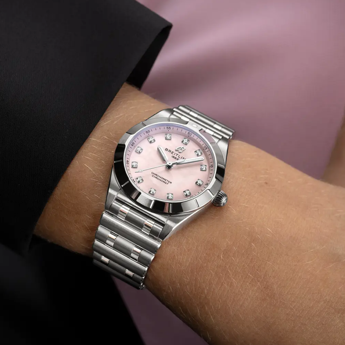 Breitling Chronomat Automatic pink mother of pearl dial watch worn on wrist with stainless steel bracelet