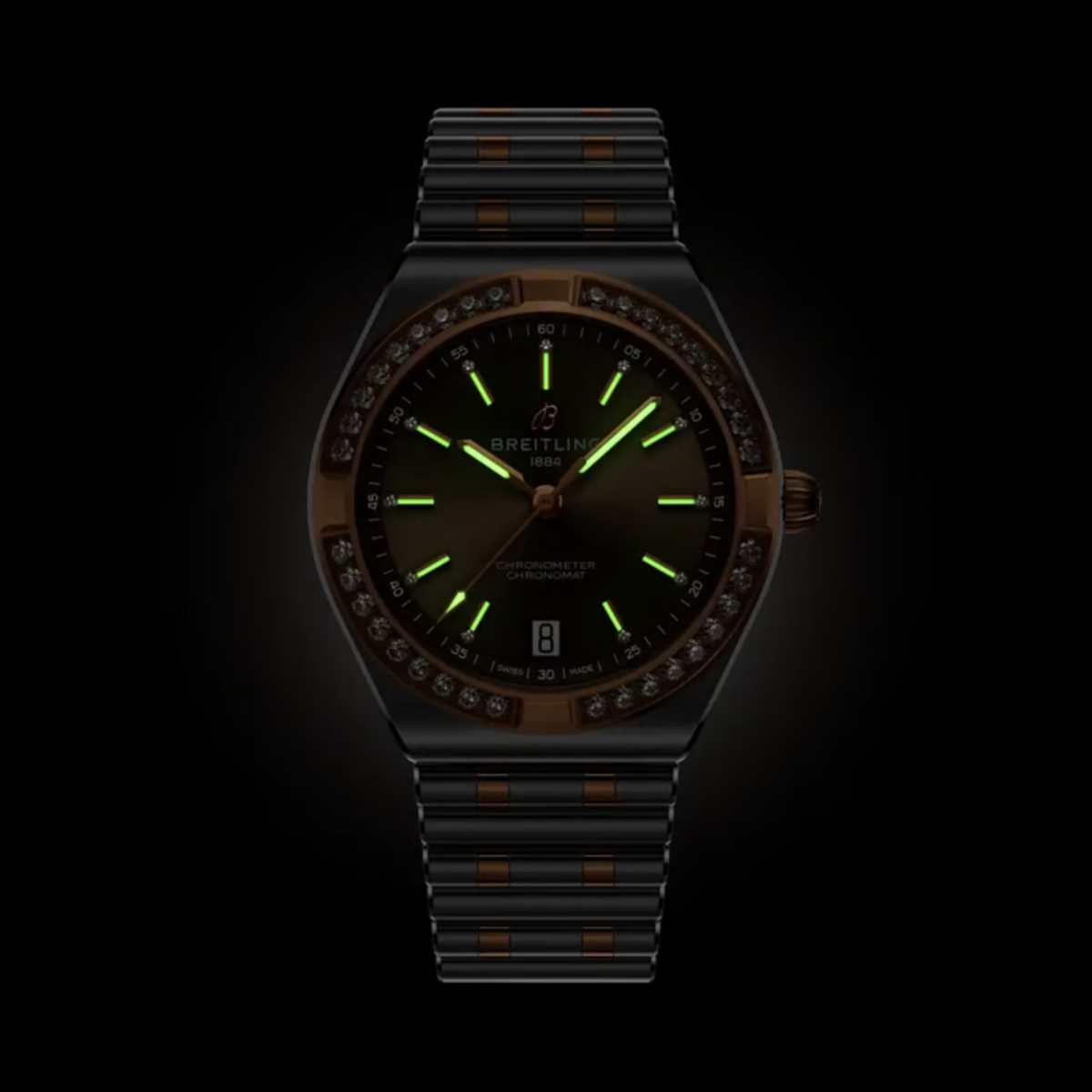 Breitling Chronomat watch with illuminated hands and hour markers in low light.