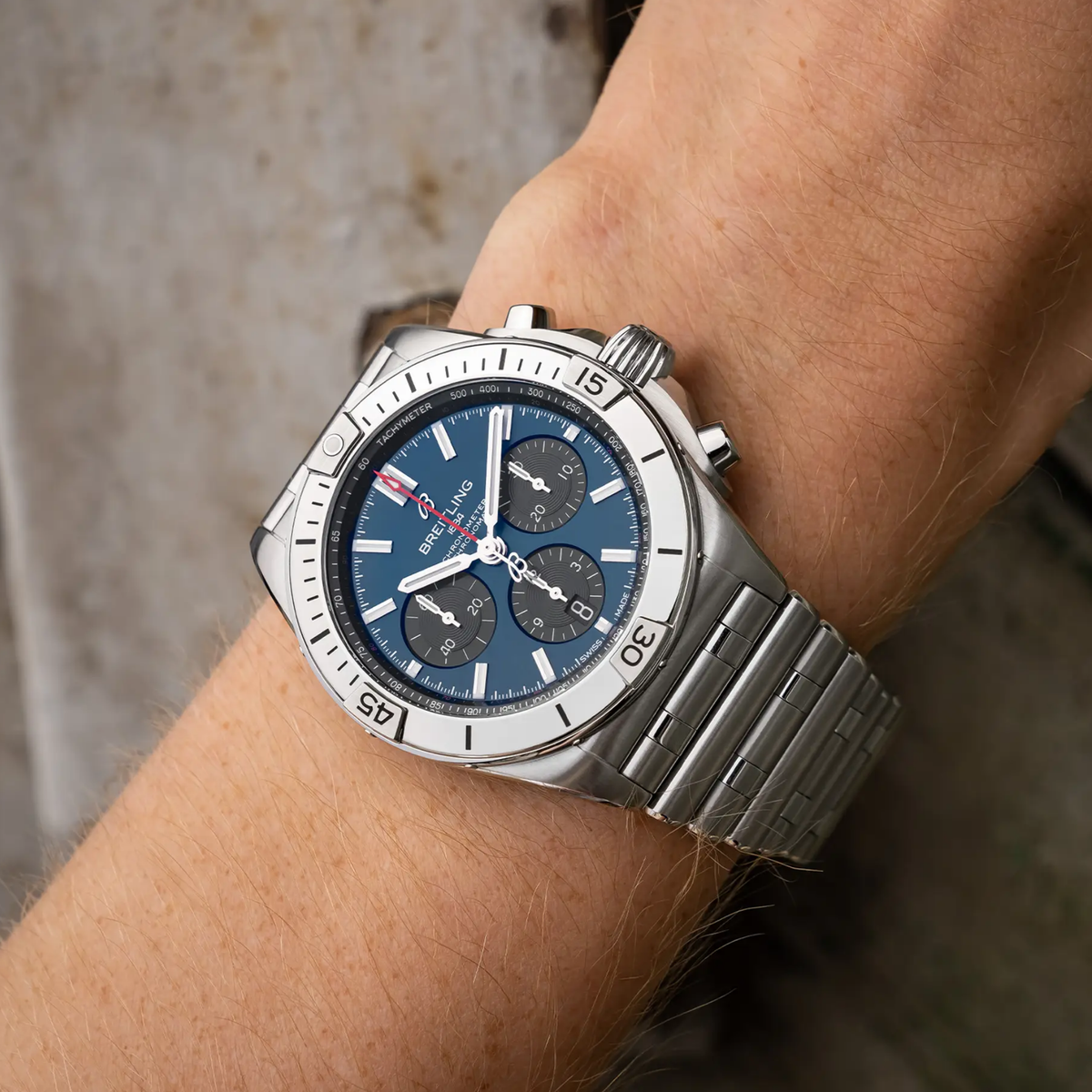 Breitling Chronomat chronograph blue dial watch worn on wrist with stainless steel bracelet