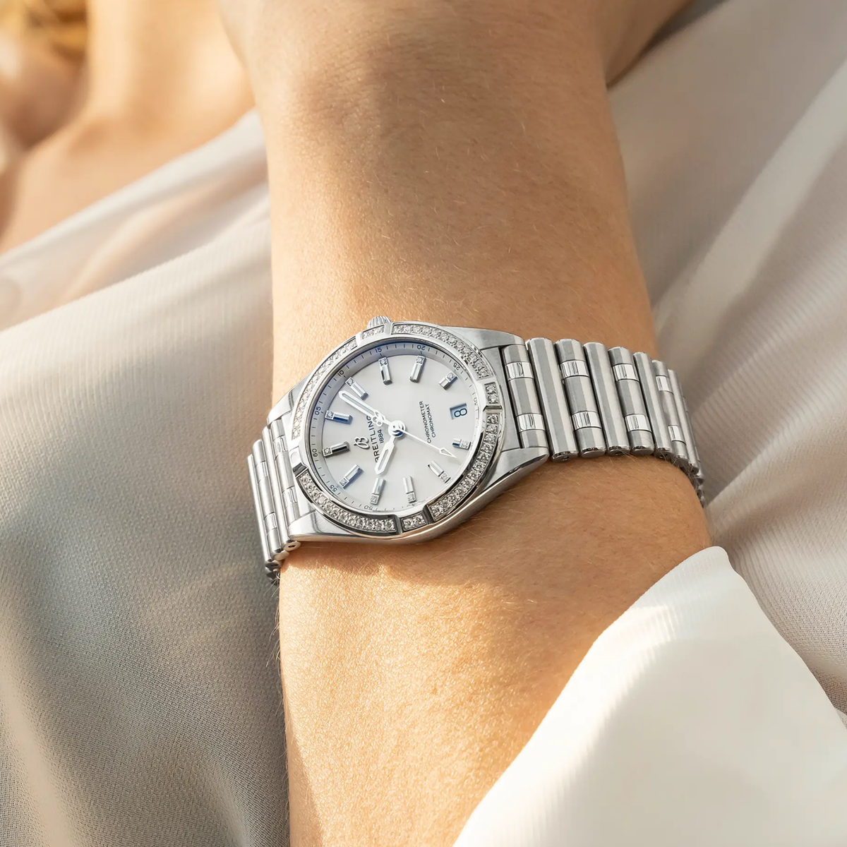 Breitling Chronomat Automatic cream dial diamond bezel watch worn on wrist with stainless steel bracelet