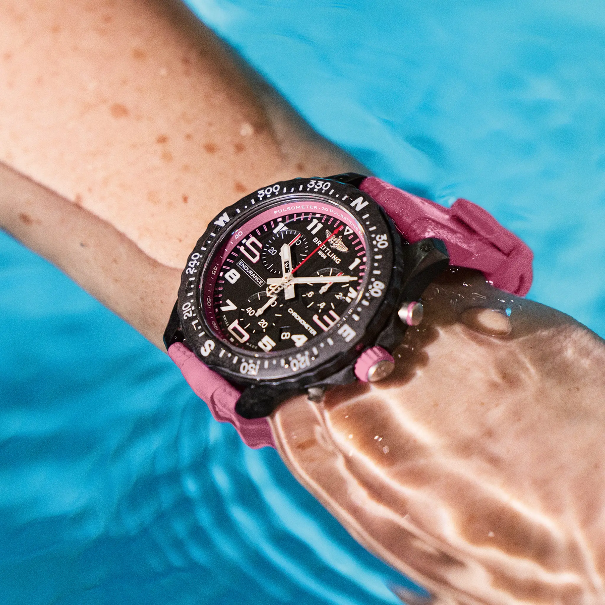 Breitling Endurance Pro chronograph black dial watch worn on wrist with pink rubber strap