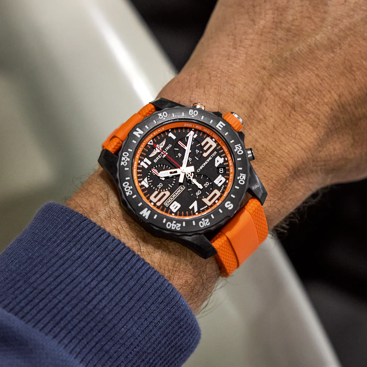 Breitling Endurance Pro chronograph black dial watch worn on wrist with orange rubber strap