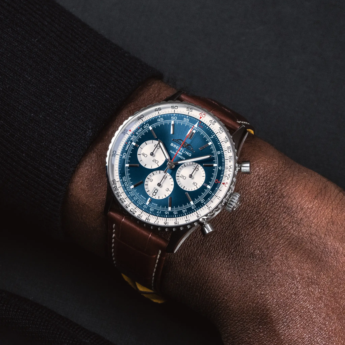 Breitling Navitimer blue dial leather strap watch styled on wrist with a classic aviation-inspired look