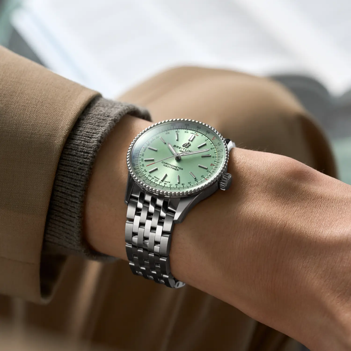 Breitling Navitimer Automatic green dial watch worn on wrist with stainless steel bracelet